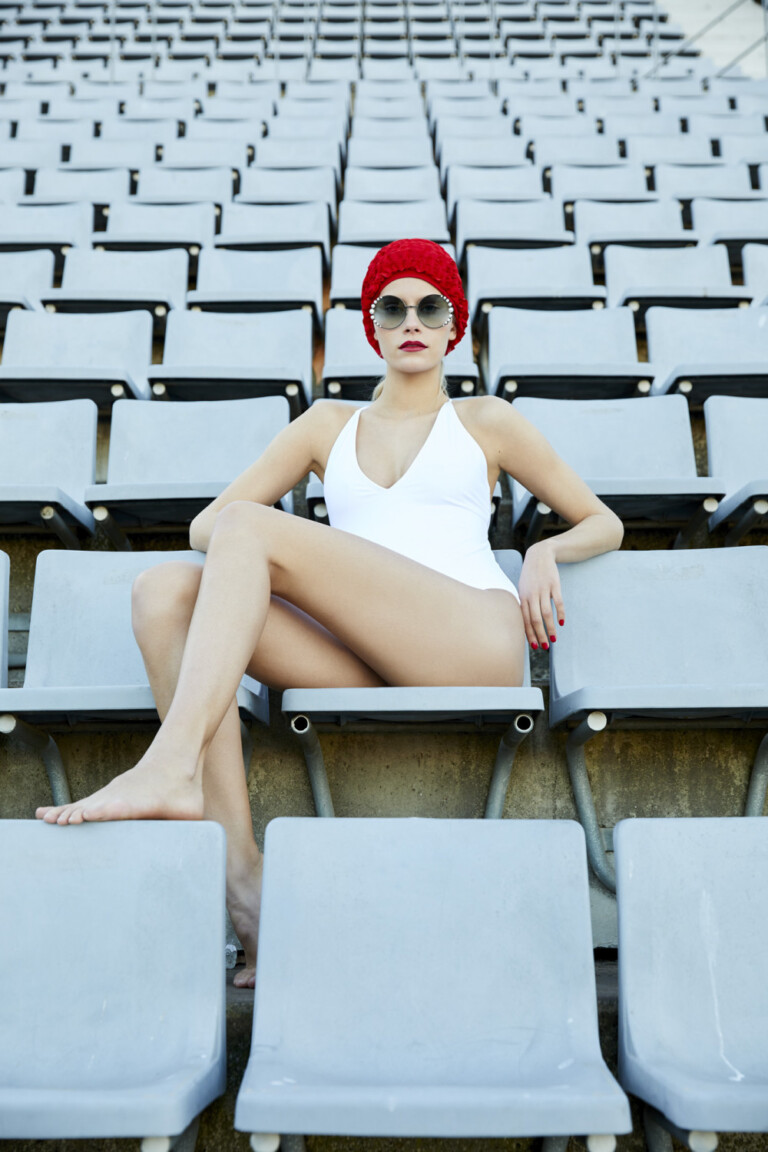 modelo sentada en las gradas con traje de piscina